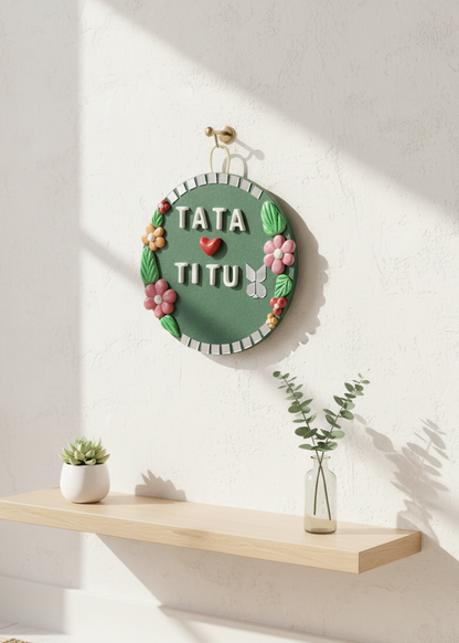 Decorative wall piece with 'TATA TITU' text on a white wall.